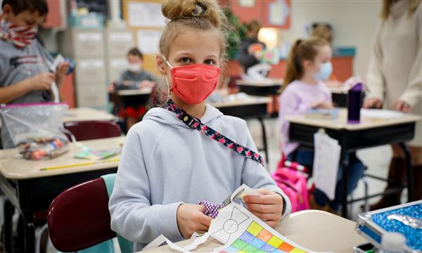 Girl works on paper kite